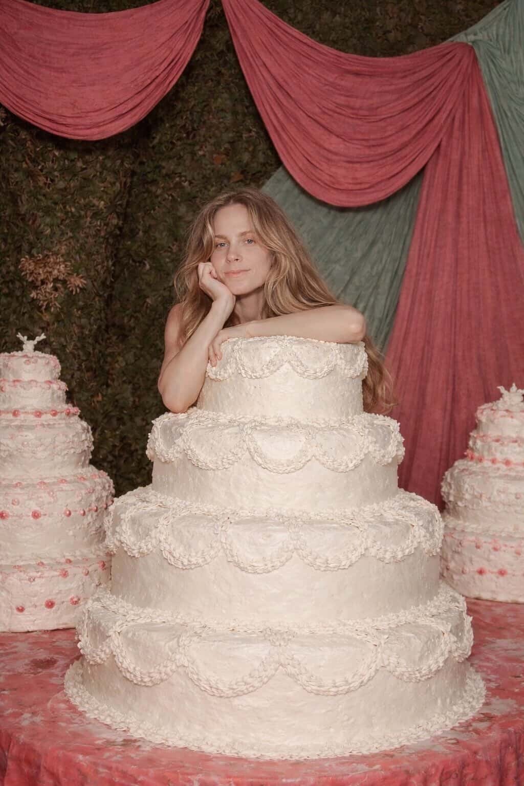 Alyce surrounded by her beautiful white scalloped cakes